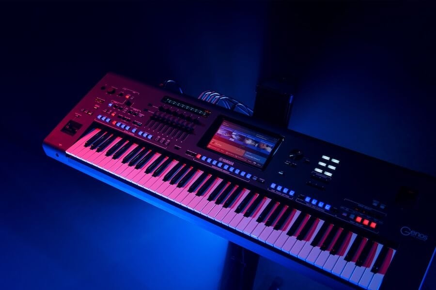 The Yamaha Genos keyboard on stage in moody lighting