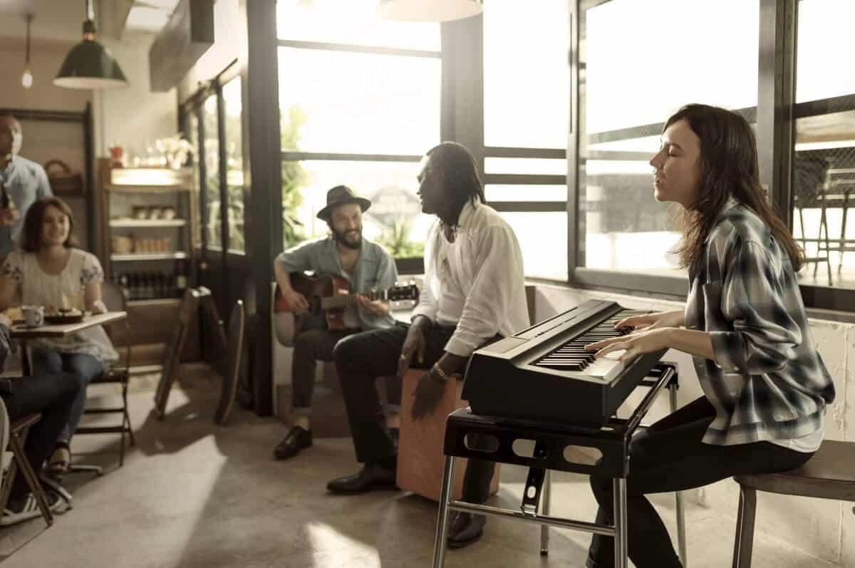 the yamaha p-121 stage piano being played in a cafe with super cool looking people
